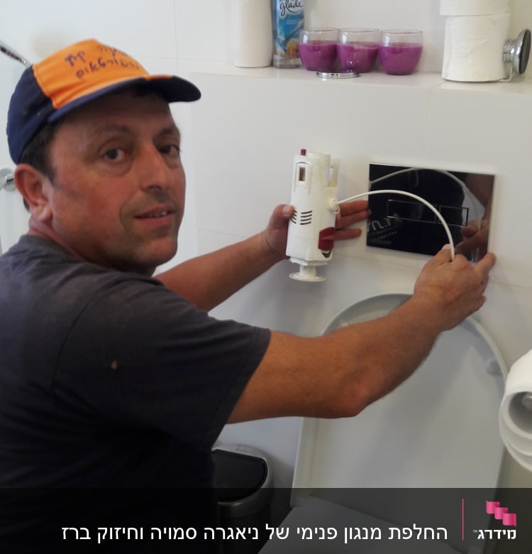 אדם מתקין חלקים במיכל הדחה של אסלה